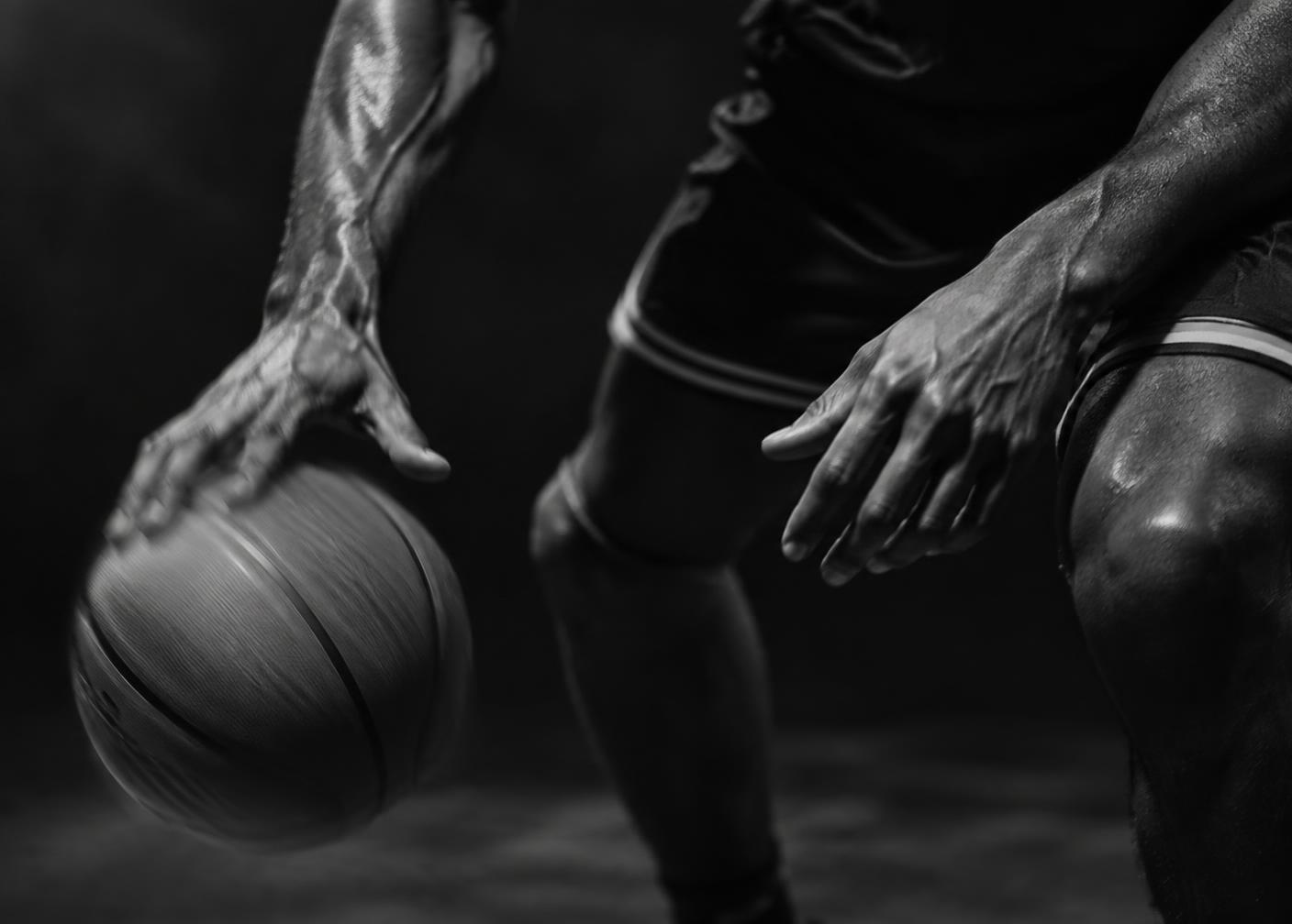 Close-up of an athlete's hands controlling a basketball mid-dribble